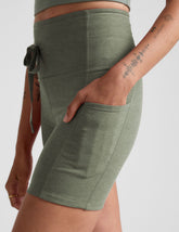 green high-waisted 5" inseam biker shorts with pockets and a drawstring at waistband.